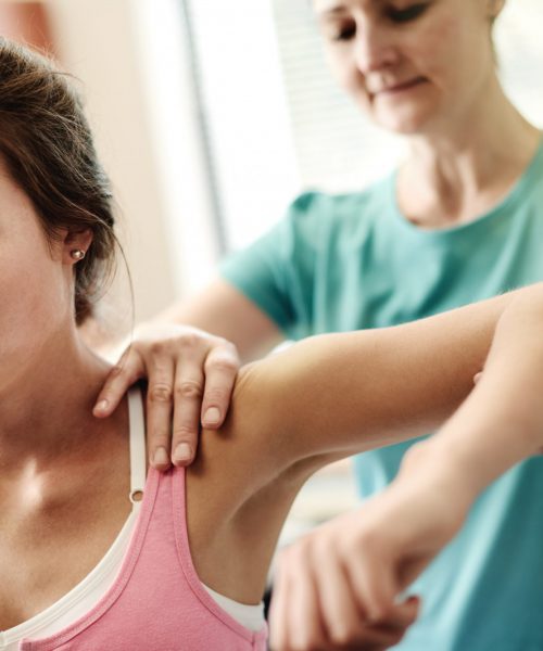 Shot of a physiotherapist massaging a patient with muscle pain in her office